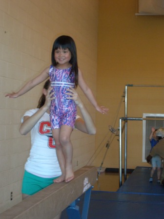 Kasen on the balance beam at gymnastics